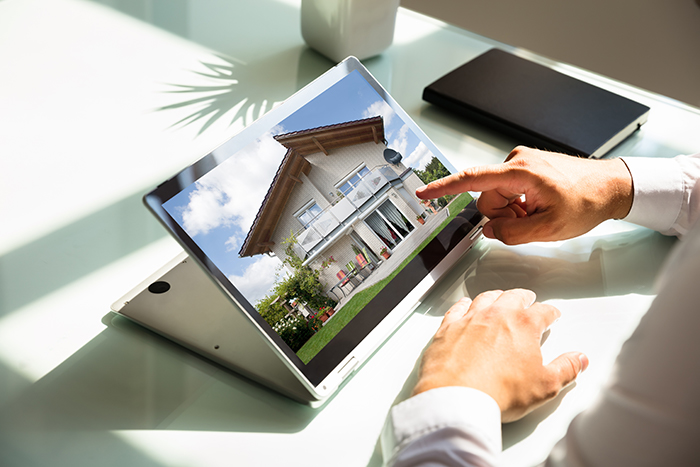 Man Using Tablet Viewing Homes Online